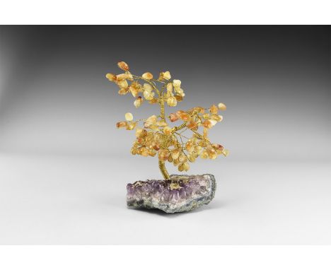 A medium size gemstone tree consisting of a brass trunk and branches tipped with polished citrines, mounted on a section of a