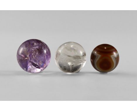 A group of three spheres consisting of one amethyst and one rock crystal, both with 'rainbows', and one of patterned agate. F