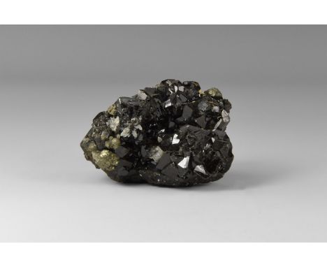 A fine group of well-crystallised cassiterite crystals with lustrous faces, from Bolivia, in old white card tray with old Gre
