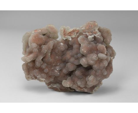 A fine specimen of Youngite jasper from Wyoming, USA, with a pink druse quartz exterior, and a polished base showing classic 