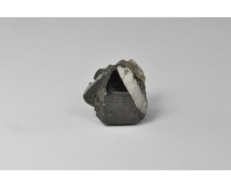 A fine single crystal of cassiterite from Cornwall, with lustrous faces and retaining some quartz matrix, in old white card t