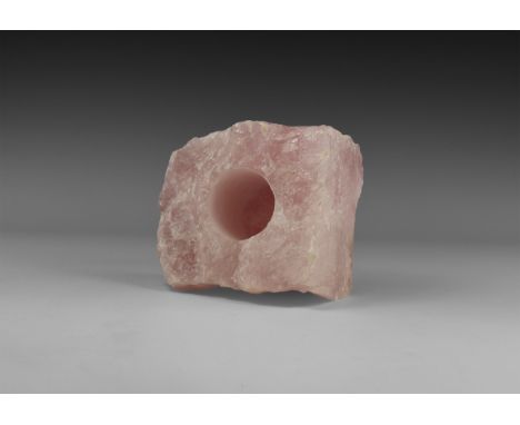 A rose quartz candle holder for either long candle or tea lights, consisting of an uncut piece of rose quartz with a 41mm dia
