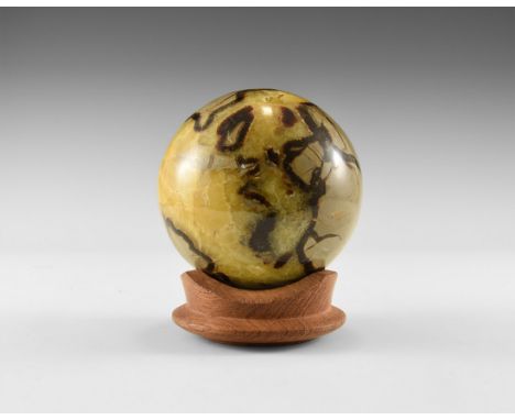 A fine sphere carved from a septarian concretion, with yellow and brown calcite, including a small hollow filled with yellow 
