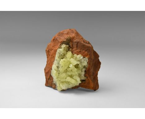 A group of yellow-green adamite crystals on red sandstone, from Mexico, with old Richard Barstow label on a file card, readin