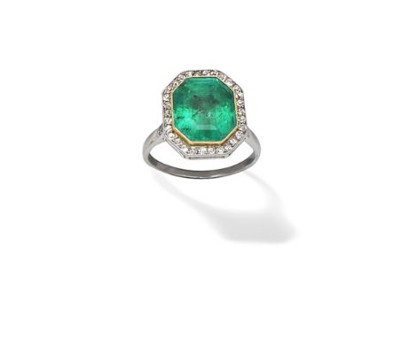 EMERALD AND DIAMOND CLUSTER RING, CIRCA 1930The octagonal step-cut emerald within a surround of cushion-shaped diamonds, betw