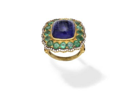 TANZANITE, EMERALD AND DIAMOND-SET DRESS RINGThe sugarloaf cabochon tanzanite within a surround of circular-cut emeralds and 