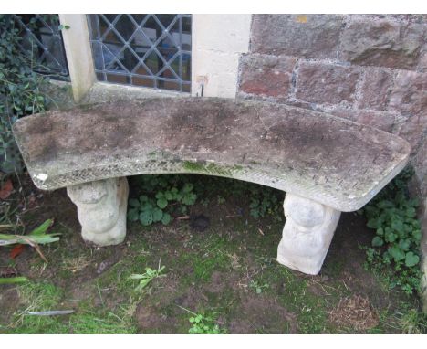 A weathered cast composition stone three sectional garden bench with curved slab seat raised on winged lion supports, 146 cm 