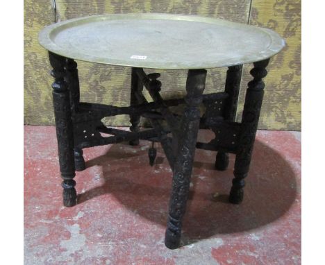 Eastern brass topped occasional table with engraved detail with folding timber base.60cm diameter 