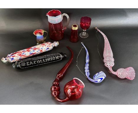 Victorian novelty glassware including a cranberry glass pipe, a Nailsea red glass pipe, Stourbridge rolling pin, a Nailsea bl