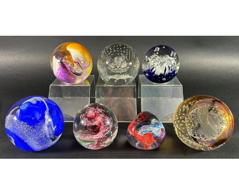 Seven Caithness paperweights, six of abstract design and one with an owl, three perspex stands included. 