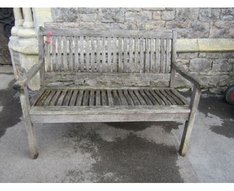 A weathered teak two seat garden bench with curved slatted seat and back (labelled to back rail Rowlinson Garden Product), 12