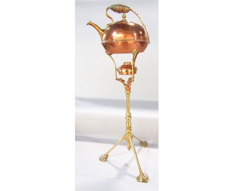 An Arts &amp; Crafts copper spirit kettle raised on three arms supported by a brass tripod column. 75cm high. 