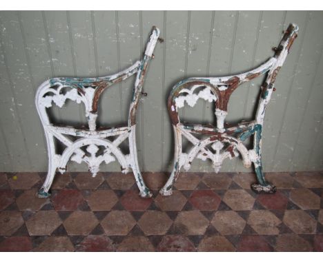A pair of Victorian cast iron bench ends, with remnants of original painted finish 