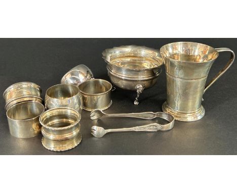 A silver group consisting of a sugar basin, milk jug, six napkin rings, etc 