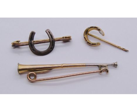 Group of antique equestrian related jewellery comprising a 15ct horseshoe stick pin, 2.1g, together with a bi-colour metal hu