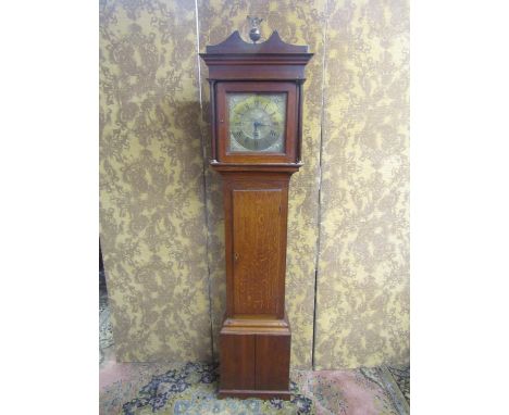 A Georgian oak longcase clock enclosing a square brass dial with cast brass spandrels and further engraved detail, subsidiary