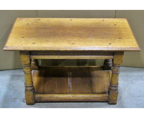 A good quality old English style oak two-tier occasional / coffee table, raised on turned supports with a planked platform un