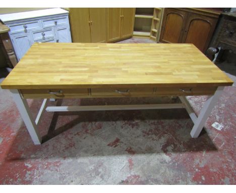 A contemporary pine kitchen/work table with three frieze drawers over painted supports and stretcher, 77 cm high x 180 cm x 8