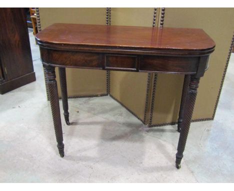 A 19th century mahogany fold-over tea table, raised on wrythen carved legs and castors, 74cm high, 90 x 90 cm (maximum) toget