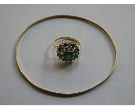 YELLOW METAL DRESS RING WITH EMERALD AND CLEAR STONES AND 9ct GOLD BANGLE 