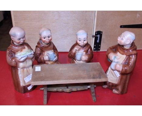 A set of four ceramic monk themed decanters made in Germany and table. 