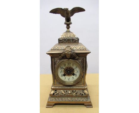 C20th brass cased mantel clock, square case with eagle finial, circular Roman dial on pierced scrolled and leaf cast base wit