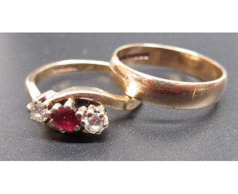 9ct yellow gold diamond and ruby crossover ring, set with a central brilliant cut ruby and two brilliant cut diamonds, stampe