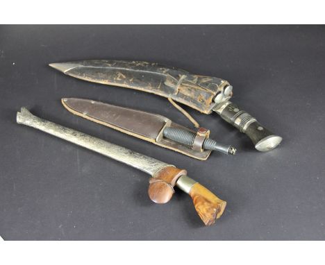 A Kukri and two smaller, in leather scabbard; a Persian knife with white metal mounted scabbard and a dagger (3)