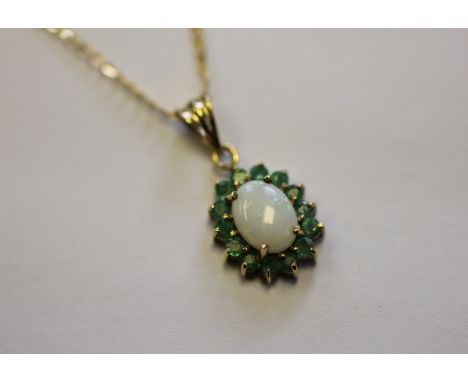 An opal and emerald pendant and attached chain, the oval opal and emerald cluster pendant, stamped '375', suspended from a fi