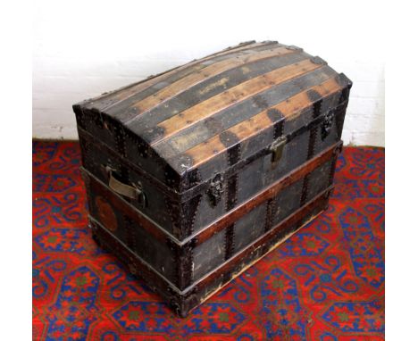 A Braden and Harris barrel top travelling trunk, wood and metal bound canvas with original label and papers to interior (lack