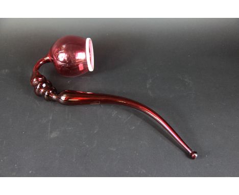 A 19th century cranberry glass pipe, 48cm long