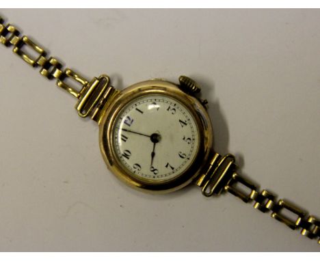 A ladies 9ct gold wristwatch, circa 1910, the circular white enamel dial with black and blue Arabic numerals, within yellow g