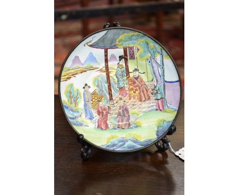 A Cantonese enamel circular dish, painted in the famille rose palette with an official and his attendants, seated beneath a p