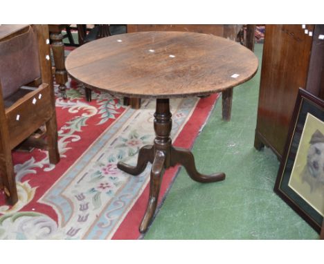 A George III oak tripod table, circular top, turned column, cabriole legs, pad feet, 73cm high, 88cm diameter