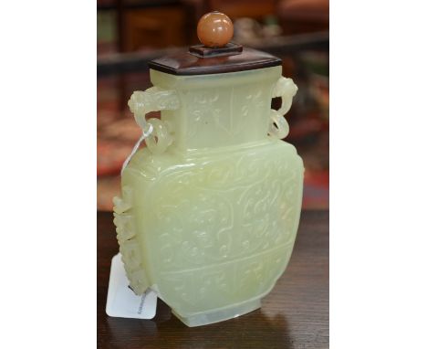 A Chinese pale celadon jade flattened ovoid vase, carved in the Archaic manner with scrolling clouds and lotus, loose ring li