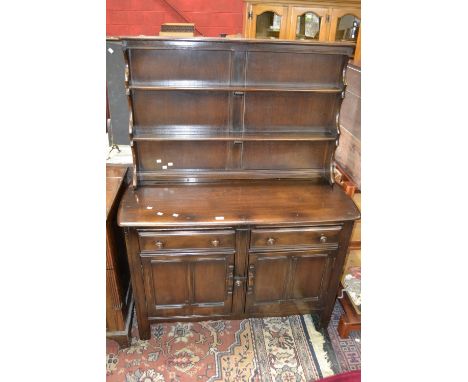 An Ercol dresser, three shelf to the top, two short drawers over two panel door cupboard to base, stile feet.