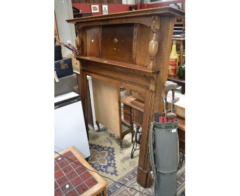 A 1940's oak fire surround, stepped mantel, turned columns, single shelf. 160cm high x 141cm wide.