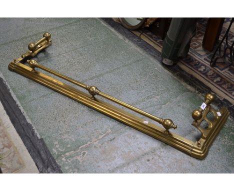 An arts and crafts fender, brass rails and finials 134cm wide