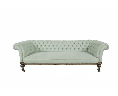 A VICTORIAN CHESTERFIELD SOFA, the button back and sides raised above padded seat, on an ebonised and parcel gilt frame and t