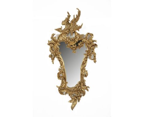 A CARVED GILTWOOD AND GESSO WALL MIRROR IN THE CHIPPENDALE TASTE, surmounted with an exotic bird, the asymmetrical frame deco