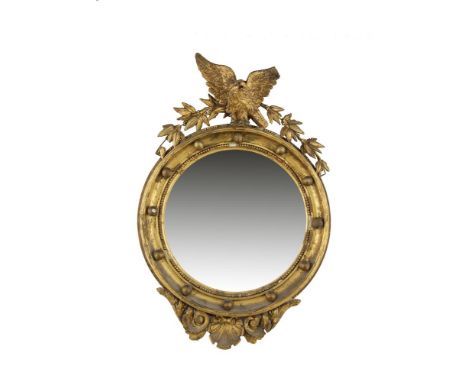 A SMALL 19TH CENTURY GILTWOOD AND GESSO CONVEX WALL MIRROR, of circular form surmounted with a carved eagle and foliage above