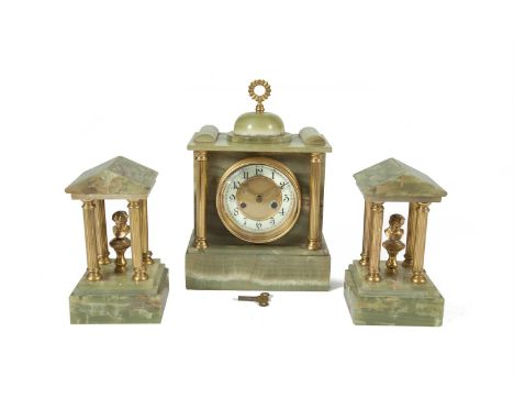 A GREEN ONYX THREE PIECE CLOCK GARNITURE, 19th century, with white enamel dial, 29cm high and two garnitures formed as temple