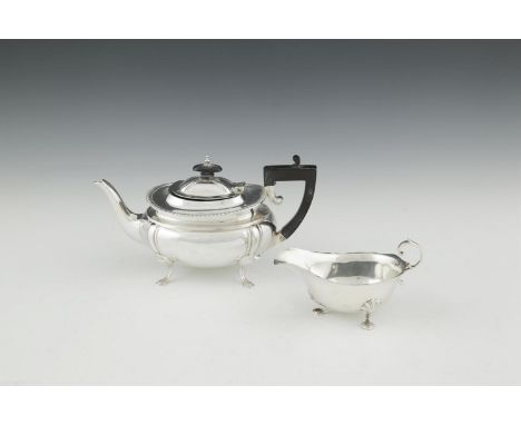 A SILVER TEAPOT, Sheffield 1910, mark of James Deakin & Sons, of oblong form, with ebon handle and finial, raised on pad feet