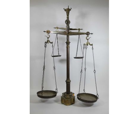 A set of Portugese brass double beam weighing scales, 20th century, surmounted by a bull's head finial, with four weighing pa