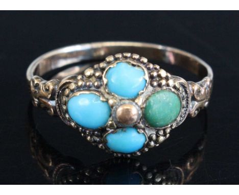 A yellow metal turquoise quatrefoil cluster ring, having four 4.6 x 3.4mm oval turquoise cabochons and engraved scrollwork sh