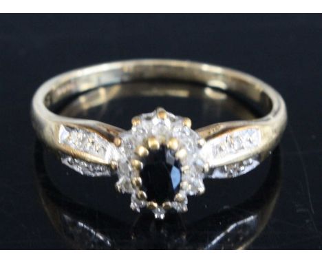 A 9ct yellow and white gold, sapphire and diamond oval cluster ring, with central oval sapphire and 16 single cut diamonds, s