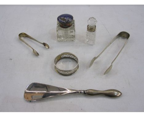 Silver-handled shoe horn, two pairs of sugar tongs, a silver napkin ring, a glass inkwell with silver collar and enamelled co