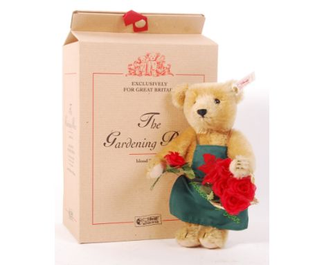 A Steiff ' Great Britain Exclusive ' teddy bear ' The Gardening Bear '. Small blonde mohair, with apron and roses. Within the