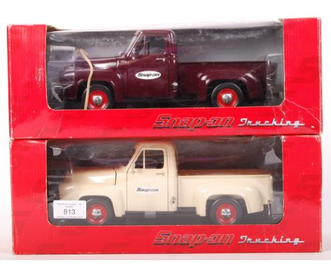 Two Snap On 1:18 scale diecast ' Trucking ' series model trucks. Both 1953 F-100 Pickups, one in cream, the other in red. Bot