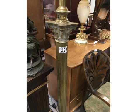 A brass standard lamp the column on square base on claw feet .